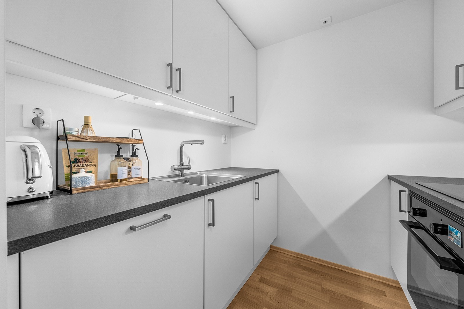 Kjøkkenet er bestående av hvit innredning og integrerte hvitevarer Galleribilde