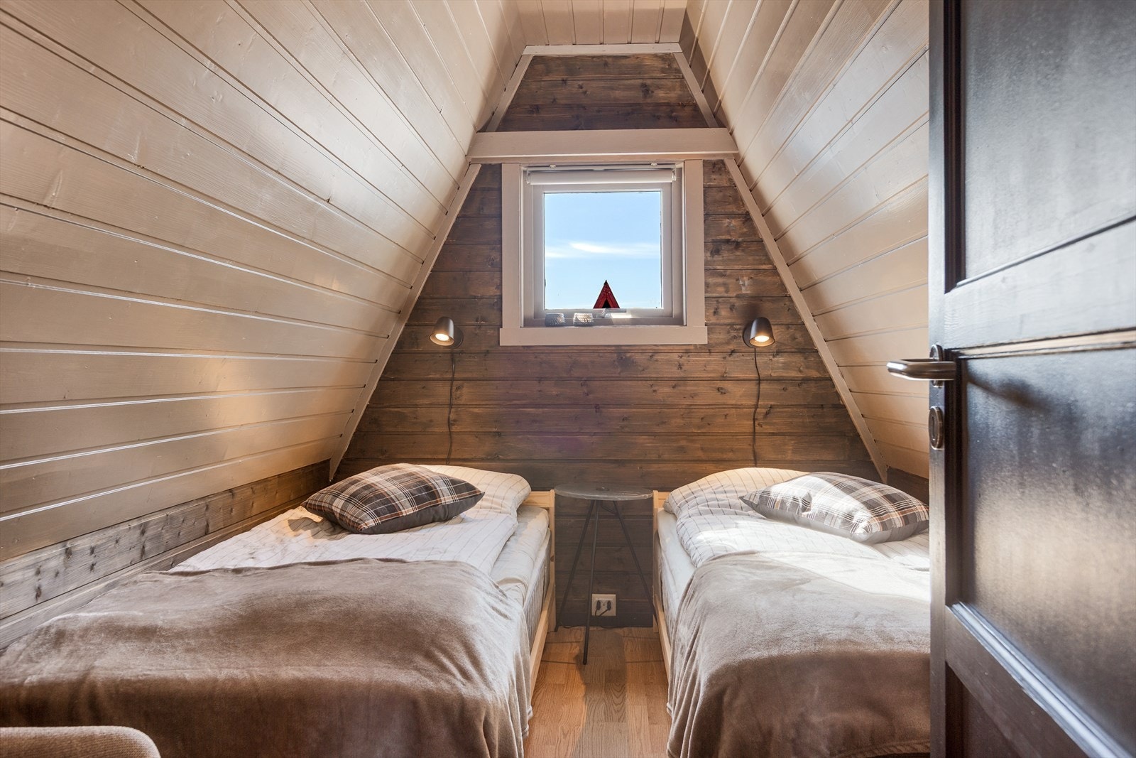 Det andre soverommet har to enkeltsenger. Som oppholdsrommet nede har også dette rommet skråtak, noe som gir en helt egen sjarm. Galleribilde