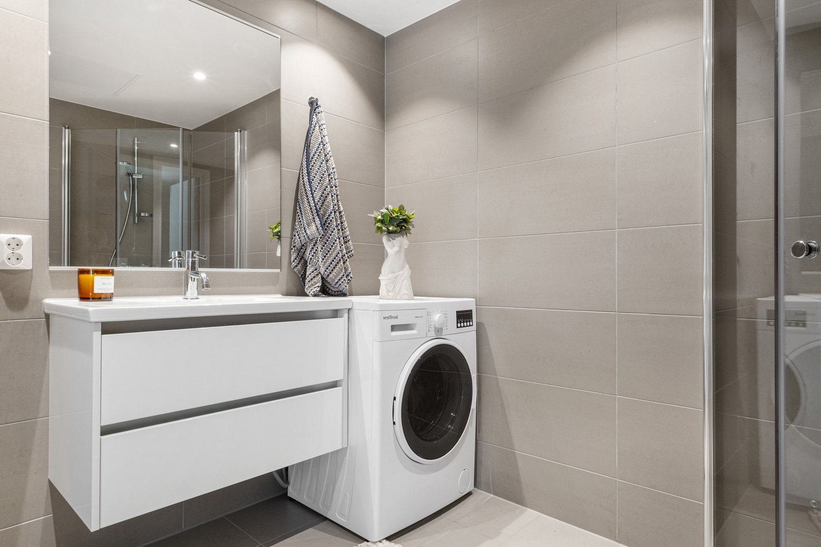 Leilighetens baderom med flislagt gulv og vegger, samt vannbåren gulvvarme. Galleribilde