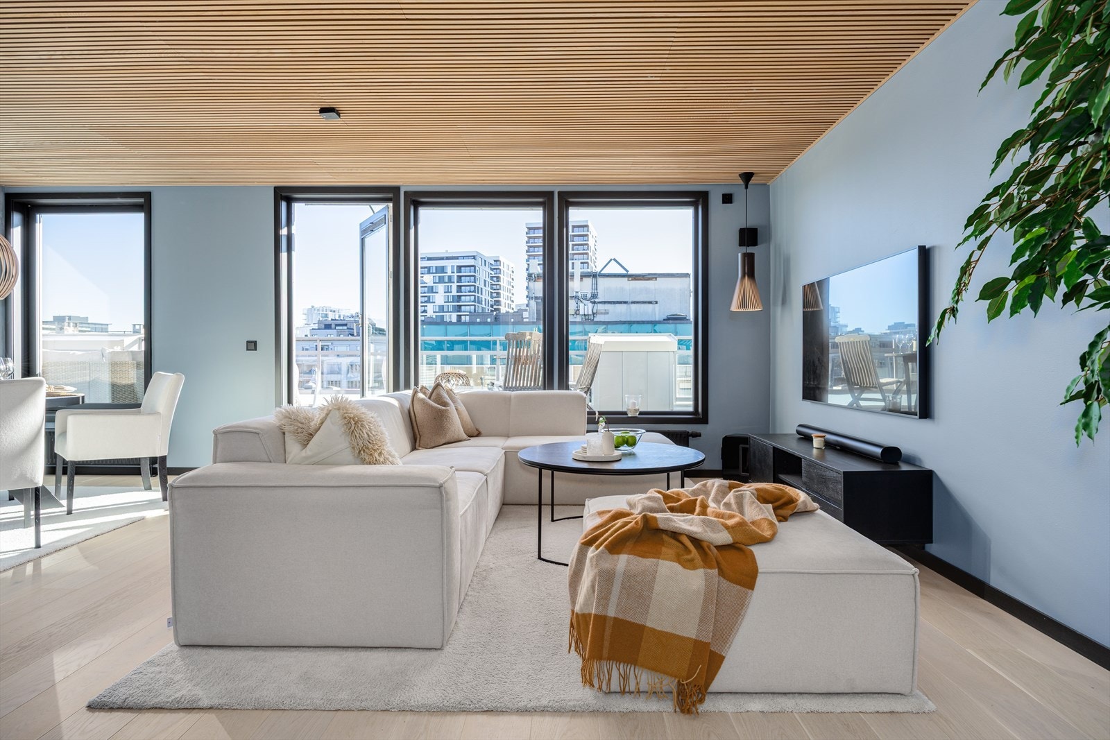 Gjennomført og harmonisk oppholdsrom der fargevalg, spilehimling og møblering skaper en elegant og balansert atmosfære. Galleribilde