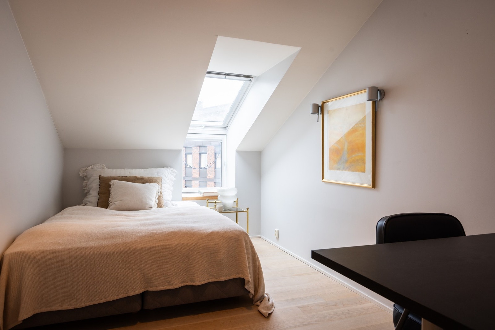 Lyst gjesterom med skråtak og takvindu. Galleribilde