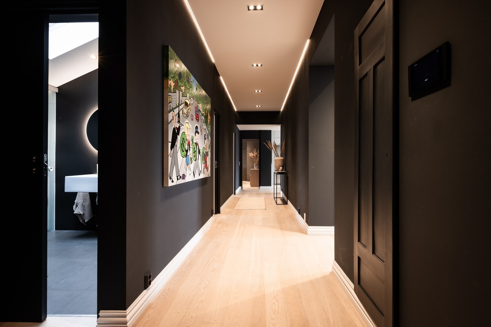 Romslig gang som knytter sammen boligen, med én stavs parkett på gulv. Galleribilde