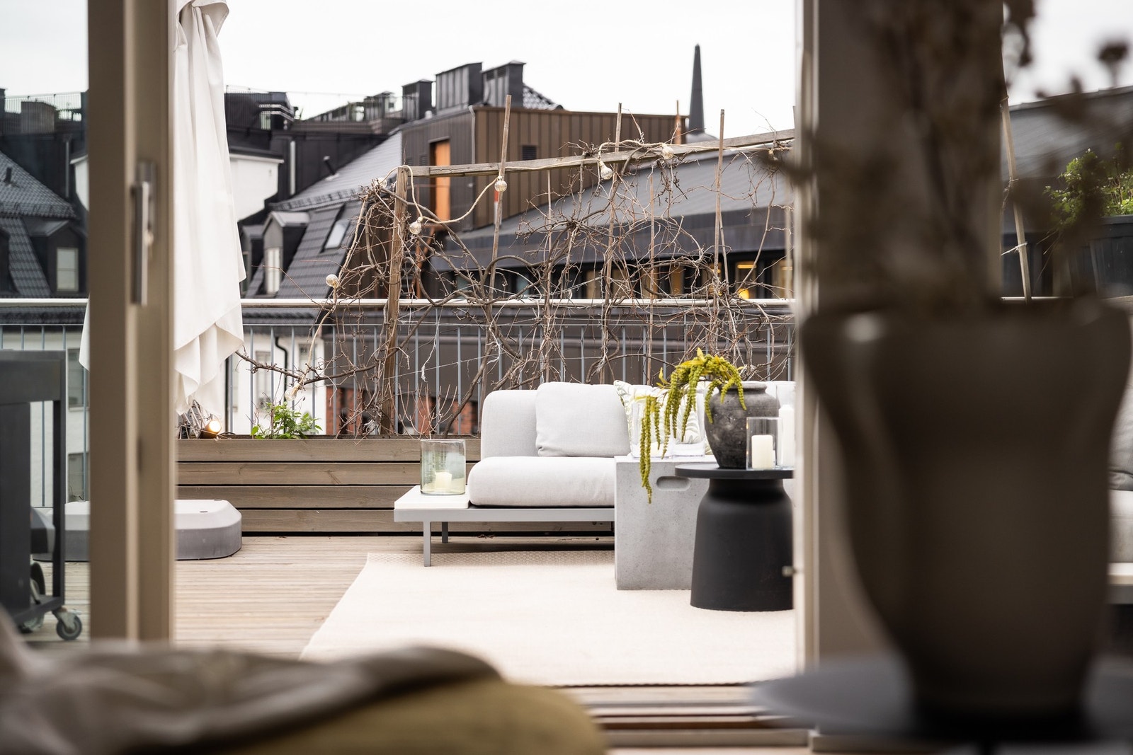 Nært utsnitt mot loungedelen av terrassen, med grønne innslag og skjermet atmosfære. Galleribilde