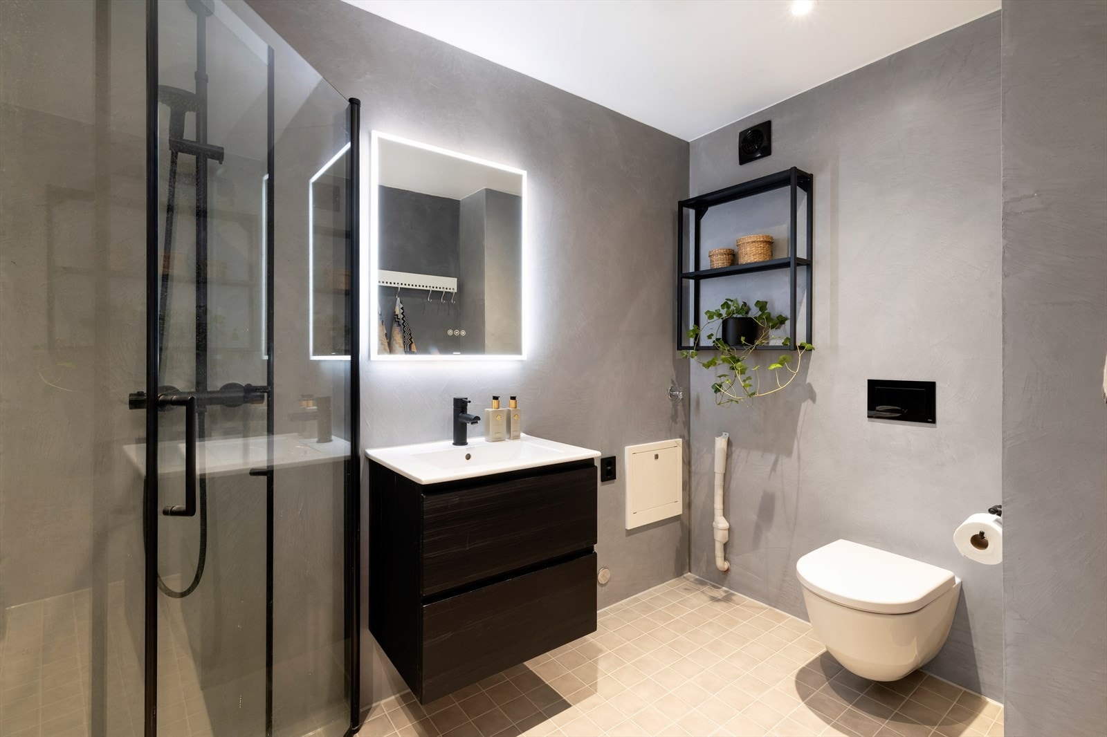 Pent bad med dusjkabinett, servant og vegghengt toalett. Galleribilde