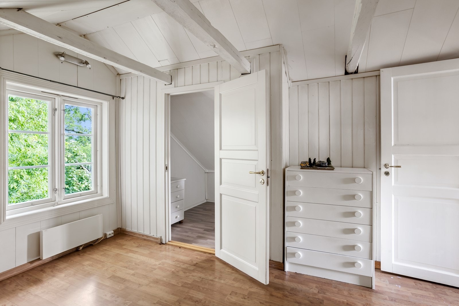 Synlige hanebjelker tilfører en fin karakter til rommet. Arken, som vender ut mot baksiden av huset i vest, sørger for god takhøyde og innslipp av naturlig dagslys! Det store vinduet mot nord søger for ytterligere naturlig lys. Galleribilde