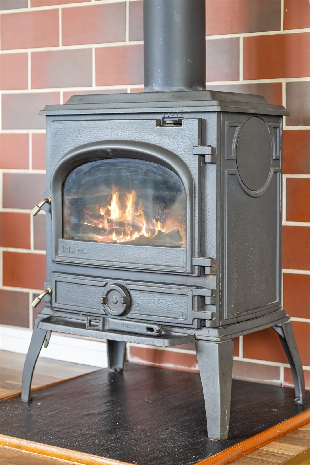 Sentralt i rommet sørger en lite plasskrevende Dovre peisovn for peiskos og ekstra god varme på mørke vinterkvelder. Galleribilde