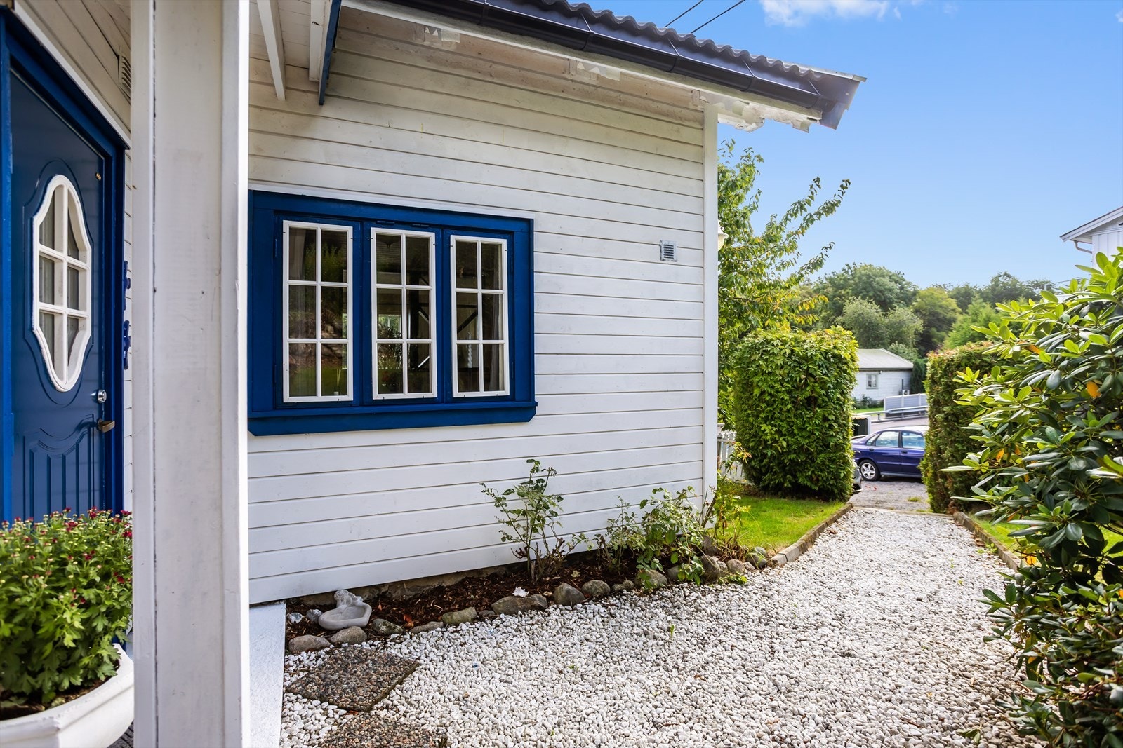 Legg merke den koselige gangstien med elvesteinsgrus og blomsterbed som leder frem til inngangsdøren. Inngangspartiet har for øvrig kort vei fra gårdsplassen. Galleribilde