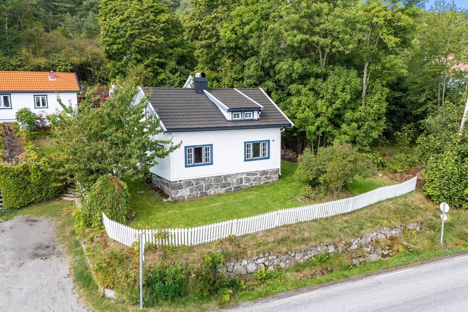 Rundt boligen er det prydbusker, frukttrær og naturpregede partier som gir en skjermet og grønn ramme. På eiendommen er det en frittstående trapp som leder opp til takterrasse, samt gangstier og mindre sitteplasser. Galleribilde