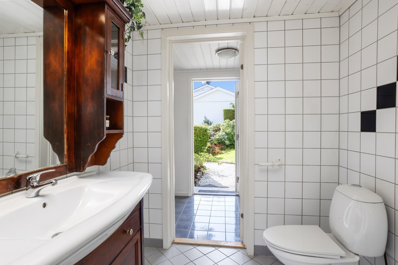 Baderomsinnredningen byr blant annet på en bred servant, underskap med både skuffer og skapdører, overskap, overskapshyller og midtstilt veggspeil. Badet har videre sokkeltoalett. Vinduet mot vest slipper inn naturlig dagslys! Galleribilde