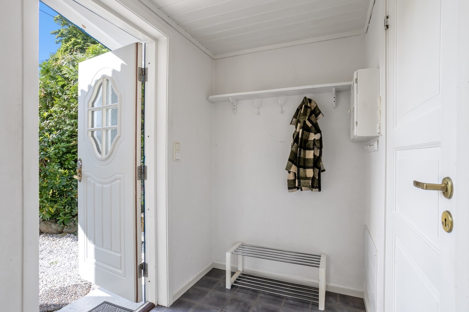 En lys entrè, som ligger i påbygg fra år 2000, ønsker deg og dine gjester velkommen inn i hjemmet. Fliser sørger for slitesterk gulvflate, varmekablene under disse gir en suveren varmekomfort. Galleribilde