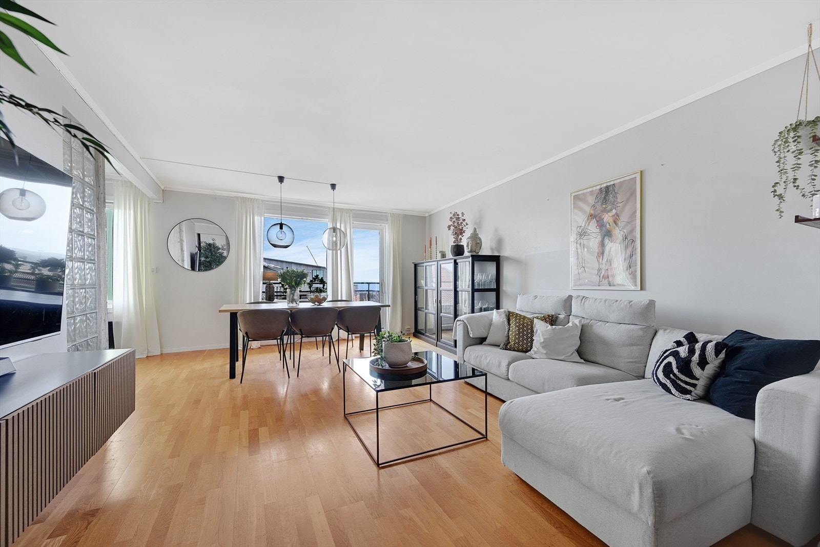 Stue og spisestue med stort vindu og glassdør mot utsikten. Galleribilde