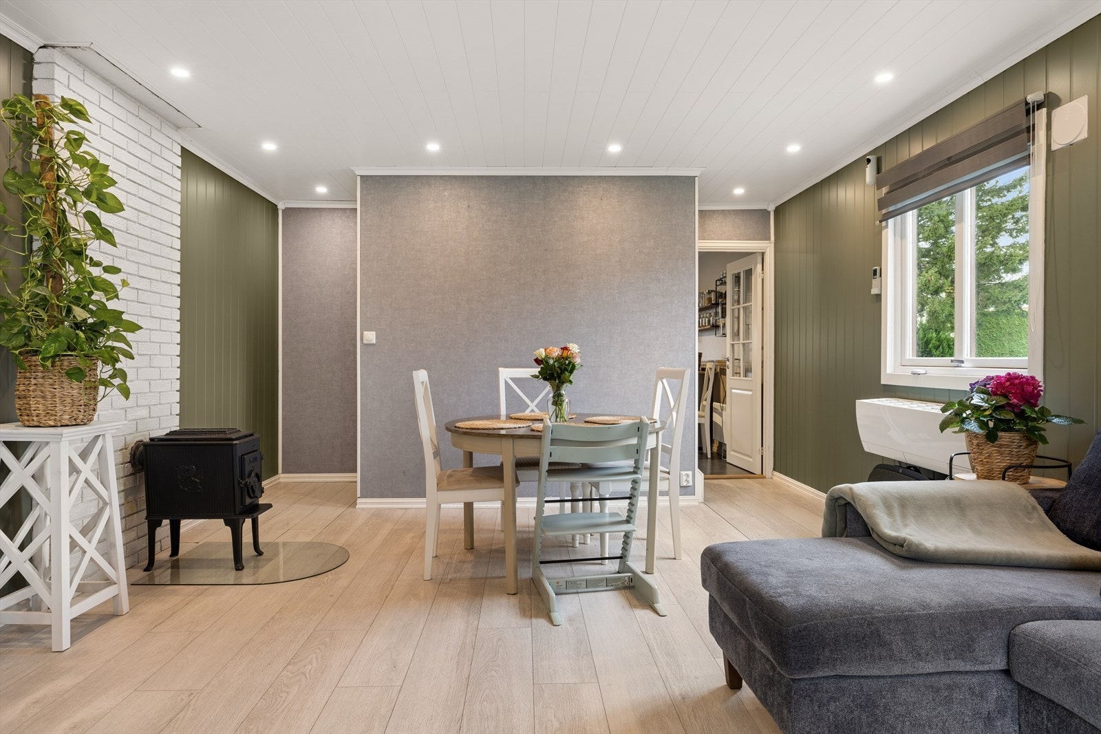 Lys og innbydende stue i hovedetasjen, omgitt av store vindusflater som slipper inn rikelig med naturlig lys og gir en luftig atmosfære. Galleribilde