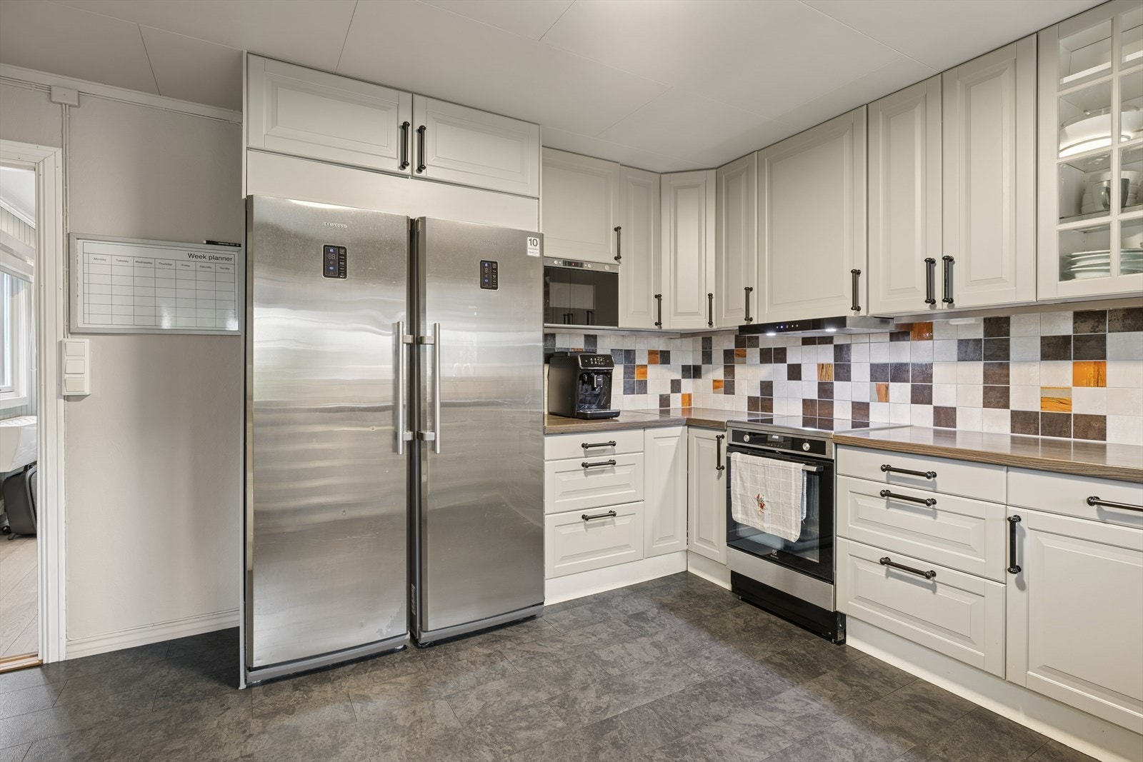 Kjøkkenet er innredet med kjøleskap, mikrobølgeovn og oppvaskmaskin. Galleribilde