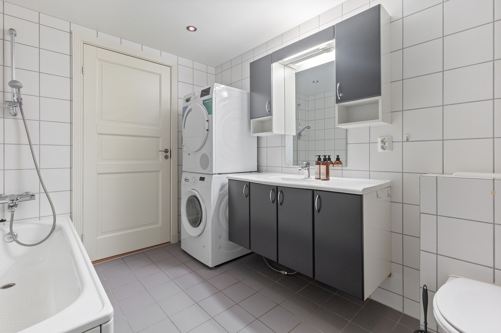 Bad/WC med dusjhjørne, badekar, vaskemaskin og tørketrommel Galleribilde