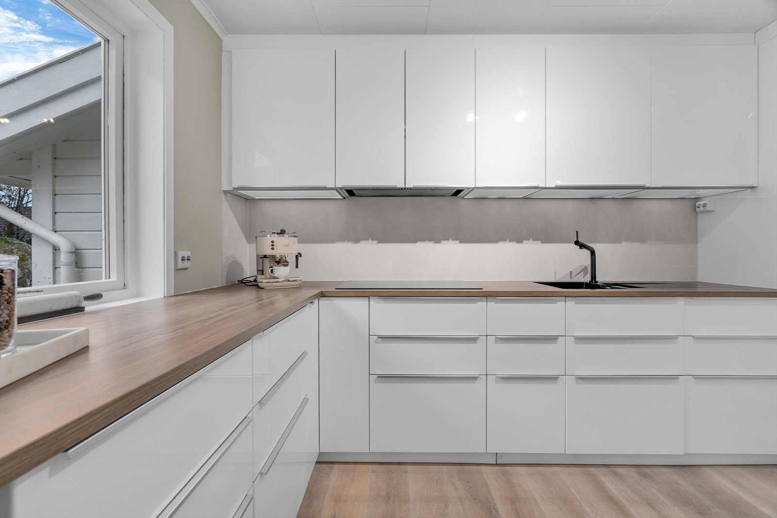 Kjøkkenet er lyst og innbydende, med en praktisk og romslig kjøkkenøy som gir både ekstra benkeplass og plass til barstoler - perfekt for hyggelige måltider eller uformelle samlinger. Galleribilde