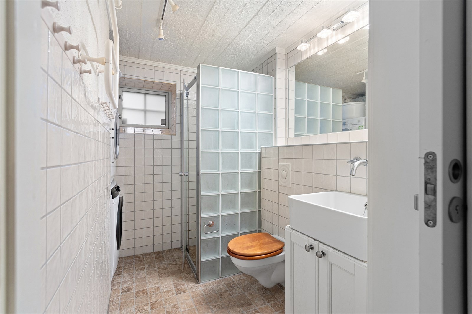 Badet i kjelleren er utstyrt med vegghengt wc, servantskap, dusj i hjørne med glassdør, samt opplegg for vaskemaskin og tørketrommel. Galleribilde
