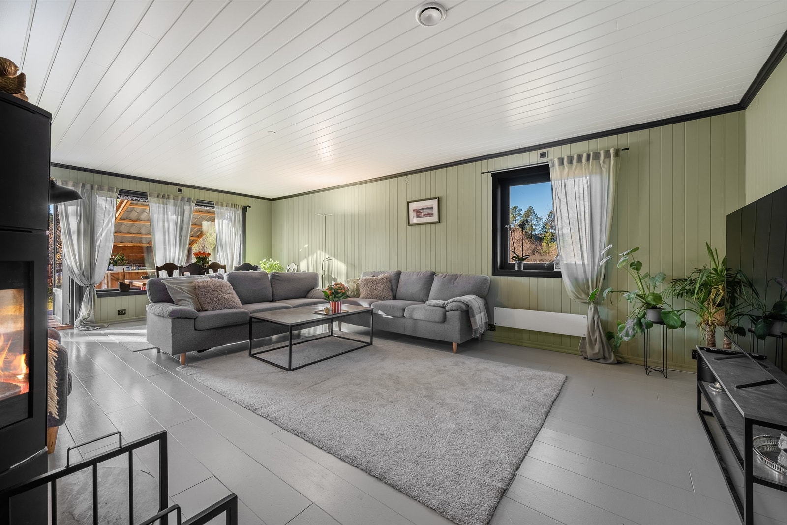 Stue med koselig peisovn og utgang solrik terrasse og hage. Galleribilde