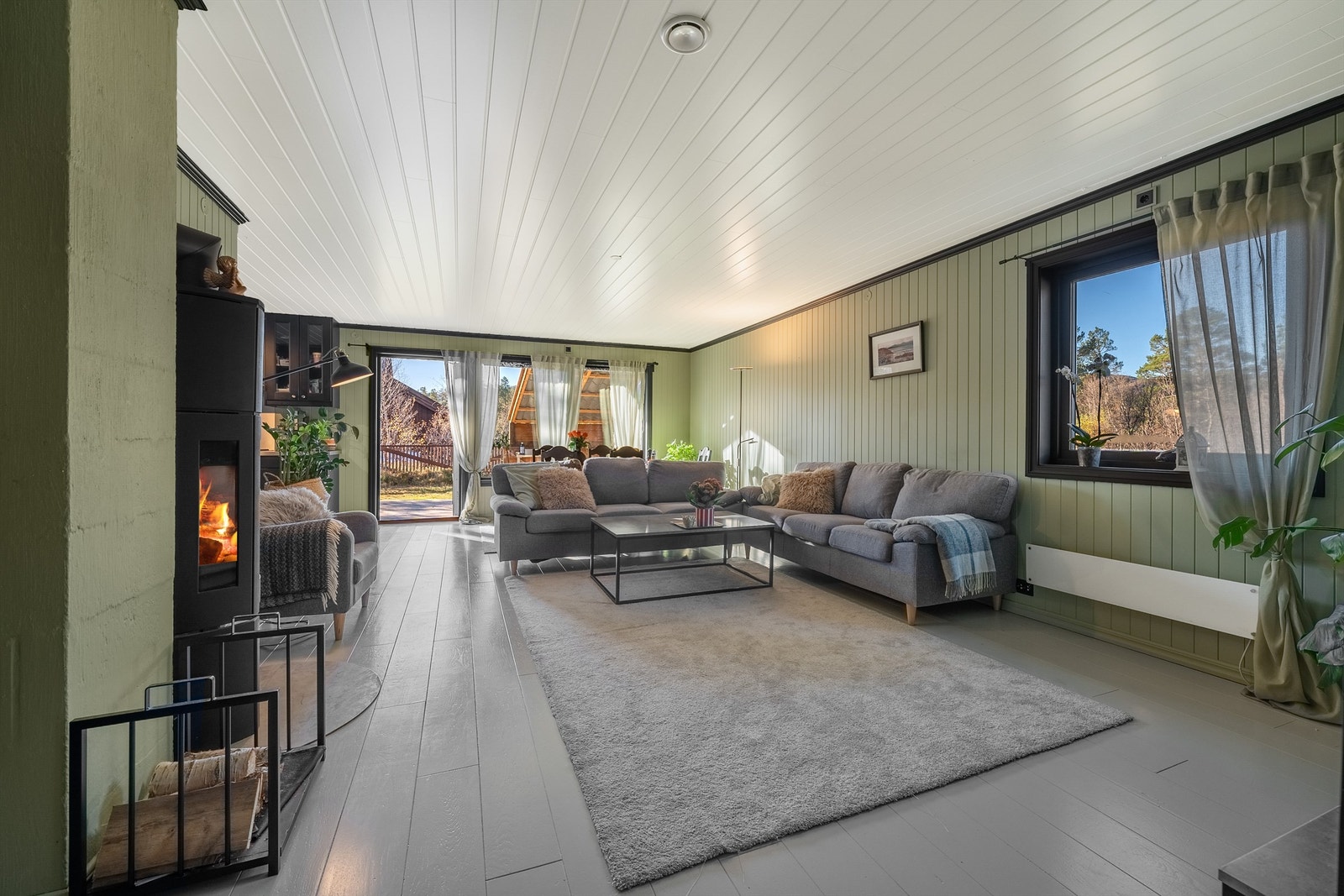 Lys og trivelig stue med peisovn og utgang til solrik terrasse og hage. Galleribilde