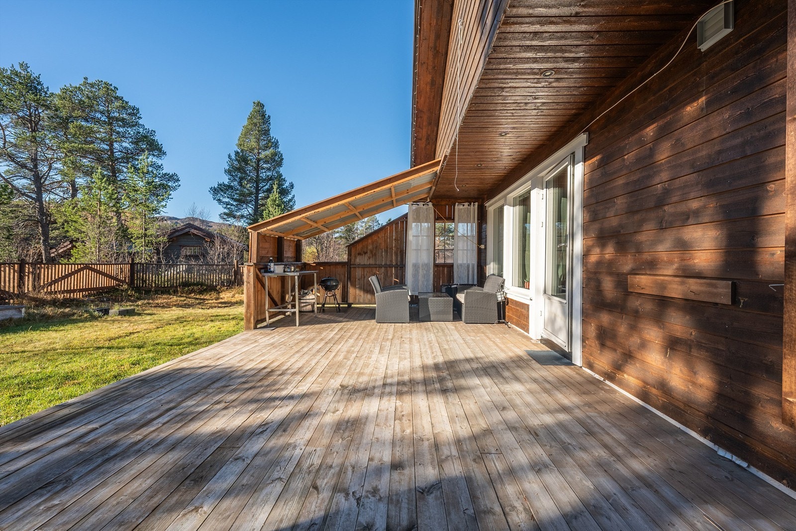 Solrik og usjenert terrasse og hage. Galleribilde
