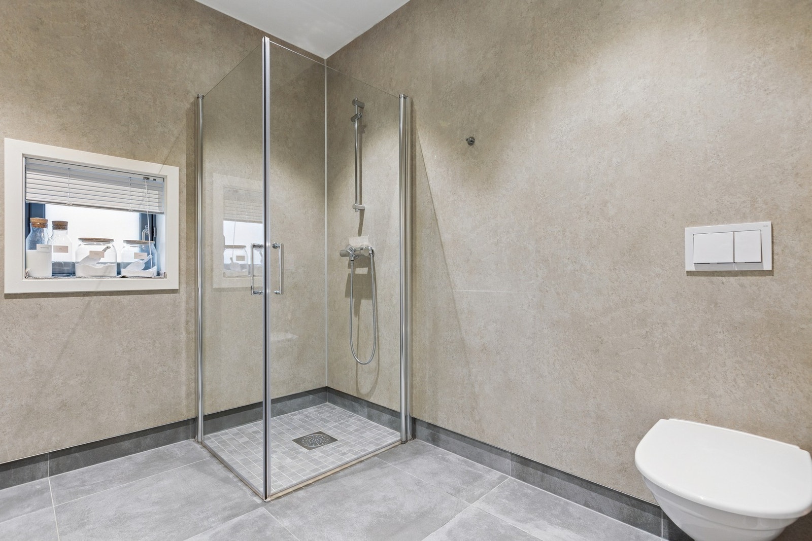 Badet har dusjhjørne med glassvegger og stilrene flater. Galleribilde