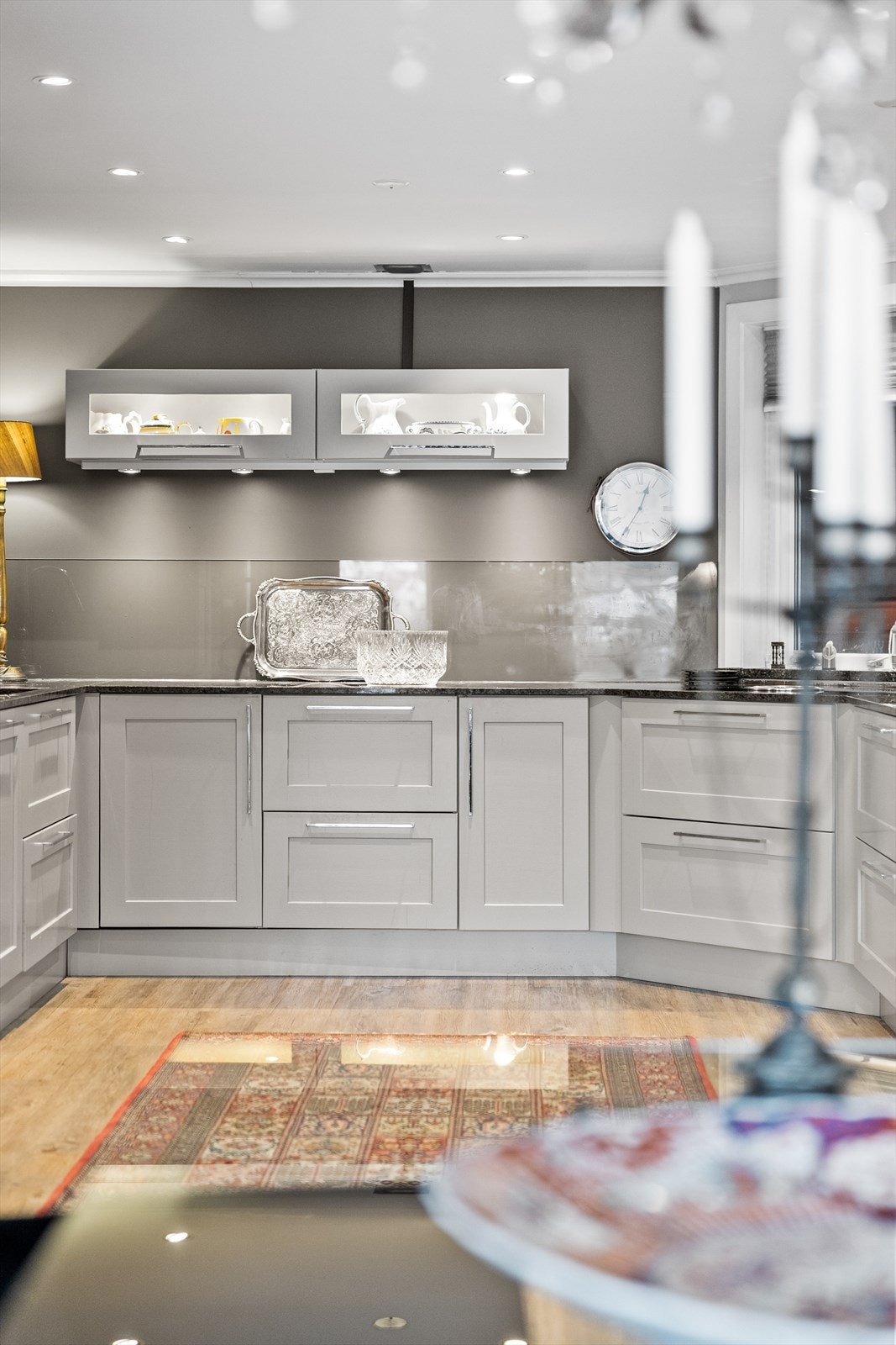 Downlights i taket gir en lun og behagelig belysning som fremhever de flotte materialene. Praktiske løsninger som vannstoppersystem i benkeskap og rikelig med både skap- og benkeplass gjør kjøkkenet både trygt og funksjonelt i bruk. Galleribilde