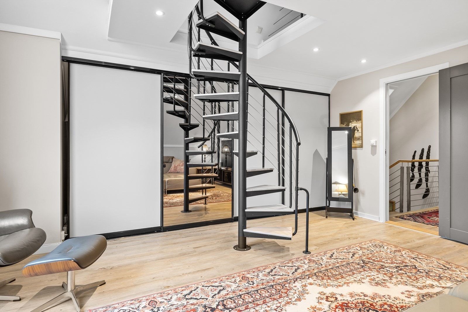 I loftstuen er det en stor og praktisk skyvedørsgarderobe som gir rikelig med oppbevaringsplass og bidrar til et ryddig og stilrent uttrykk. Galleribilde