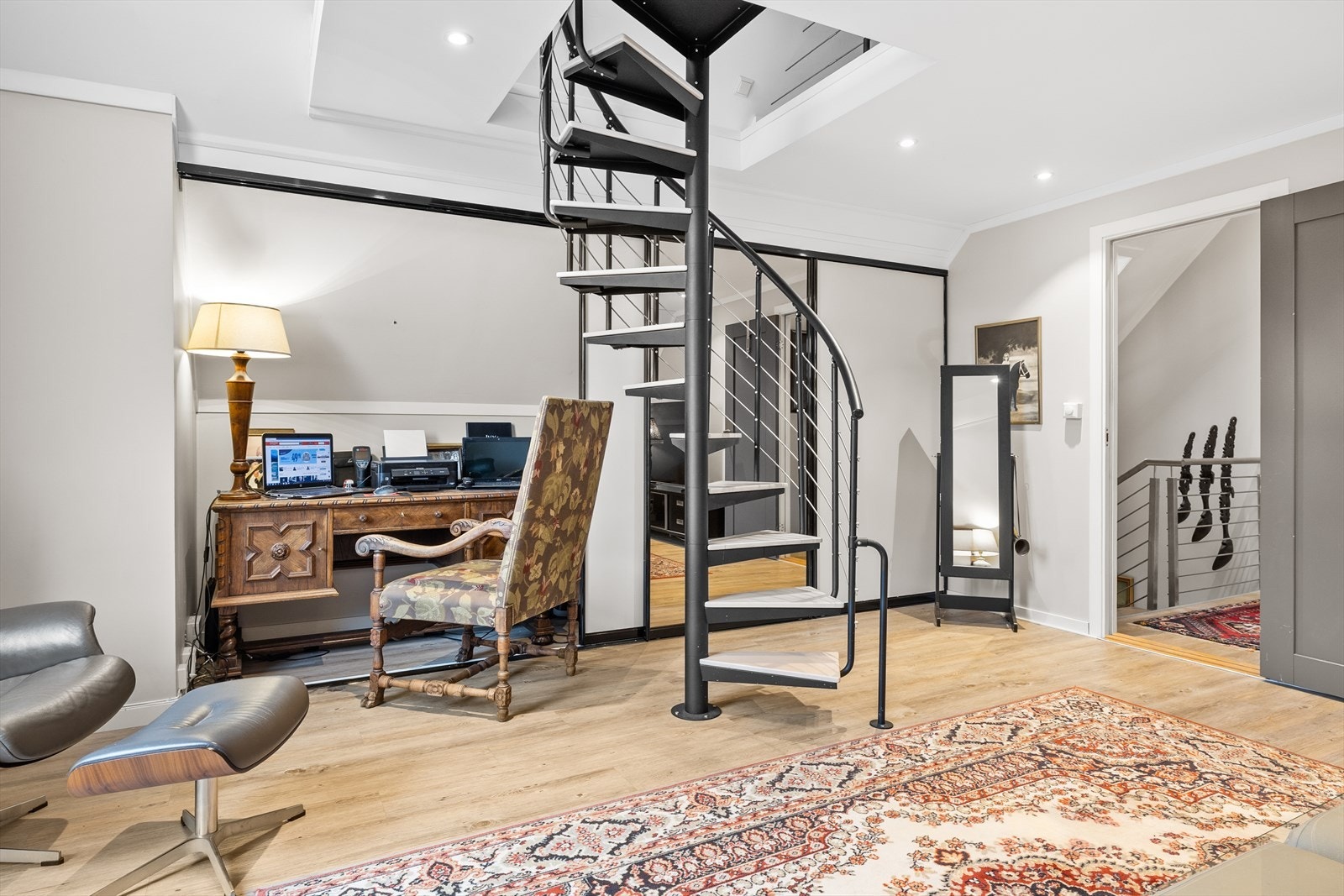 Den ene delen av garderoben er smart innredet som et praktisk hjemmekontor - en gjennomtenkt løsning som utnytter plassen optimalt og gjør rommet enda mer funksjonelt. Galleribilde