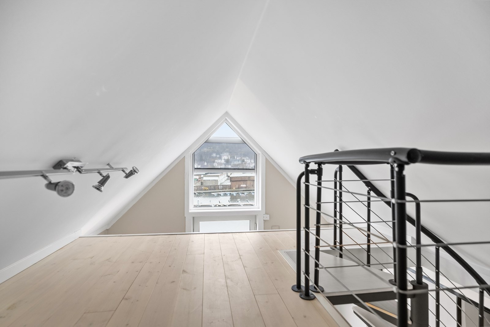 Fra loftstuen fører en stilfull trapp opp til en koselig hems - et spennende og anvendelig tilskudd til boligen. Hemsen kan brukes som ekstra oppbevaringsplass, gjestesone, hobbyrom eller en lun lesekrok, og gir en sjarmerende dimensjon til leiligheten. Galleribilde