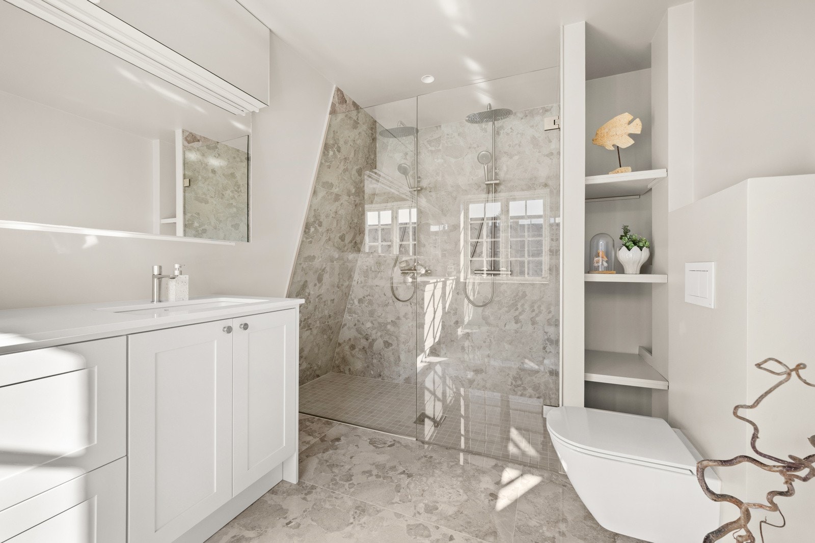 Badet tilknyttet hovedsoverommet er romslig og moderne, med fliser på gulv og vegger i dusjsonen. Galleribilde