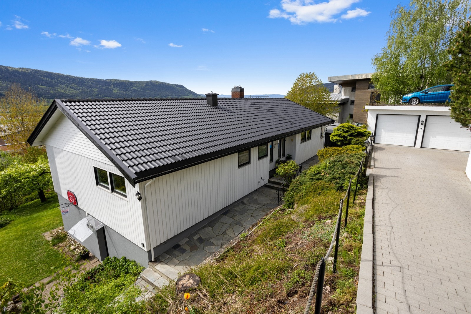 Meget innbydende adkomst til boligen med blant annet skjermede beplantninger/prydbusker og støttemur. Galleribilde