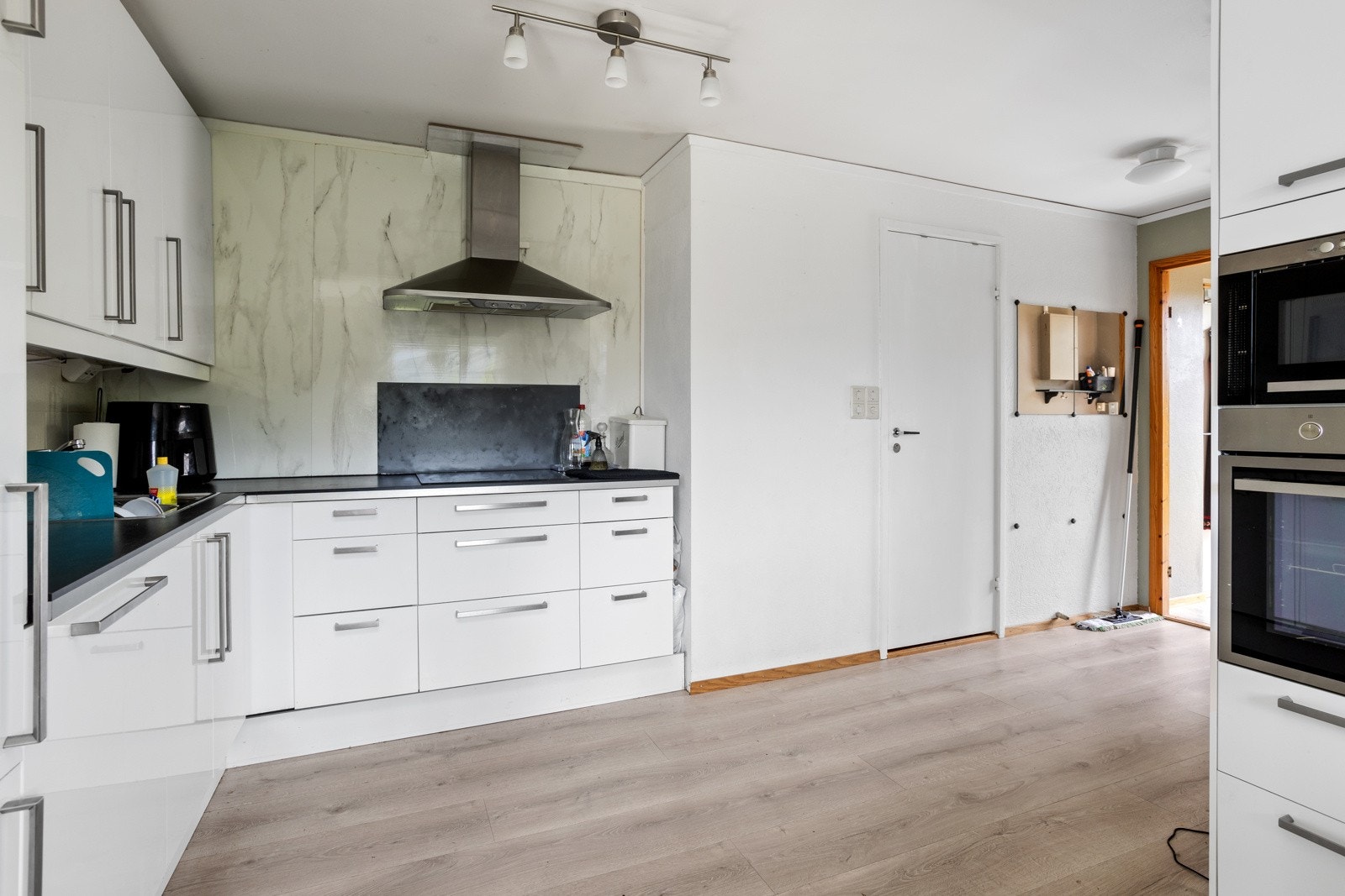 Leiligheten har en moderne og åpen løsning mot kjøkkenet. Kjøkkeninnredning med integrerte hvitevarer Galleribilde