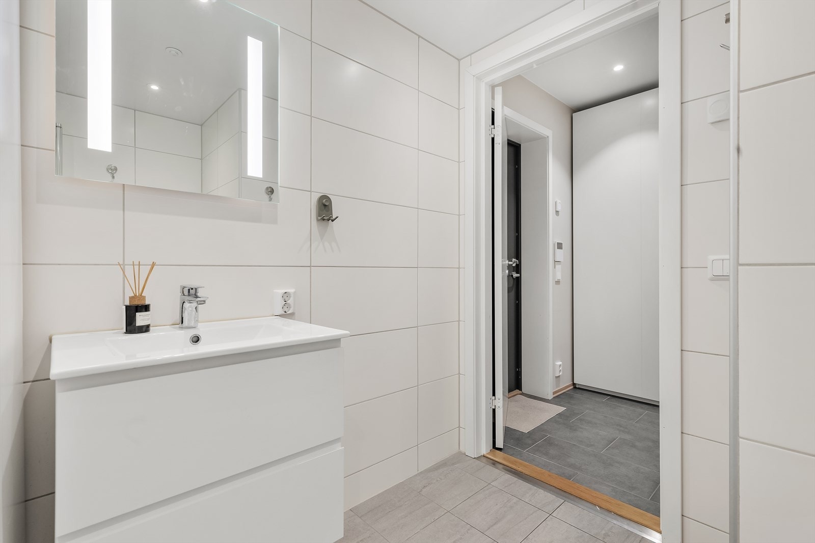 Badet er utstyrt med vegghengt toalett, dusjhjørne med svingbare glassdører, baderomsinnredning med nedfelt servant, samt opplegg for vaskemaskin og tørketrommel. Galleribilde