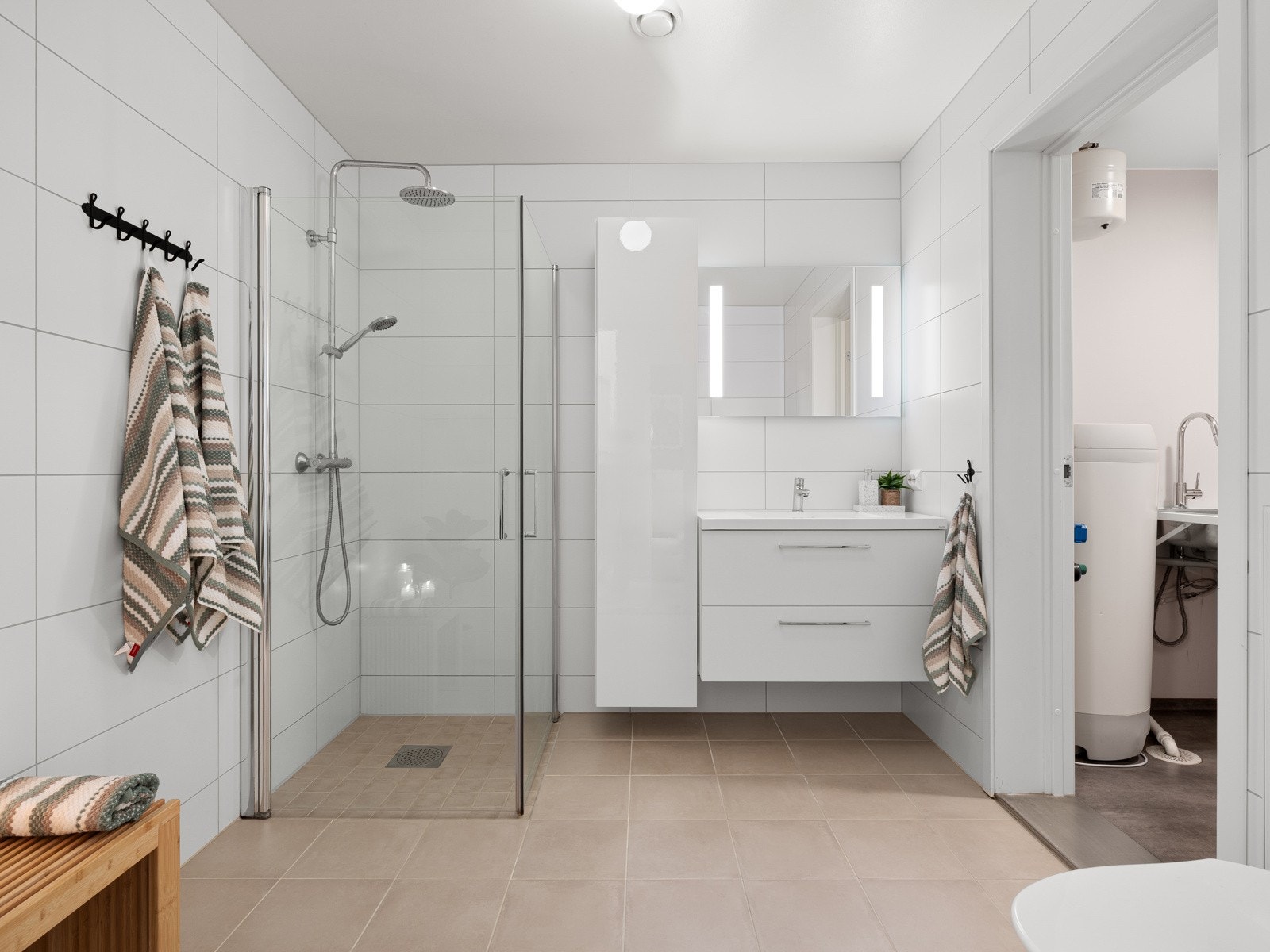 Lekkert, fliselagt bad med god størrelse og eget vaskerom til venstre Galleribilde