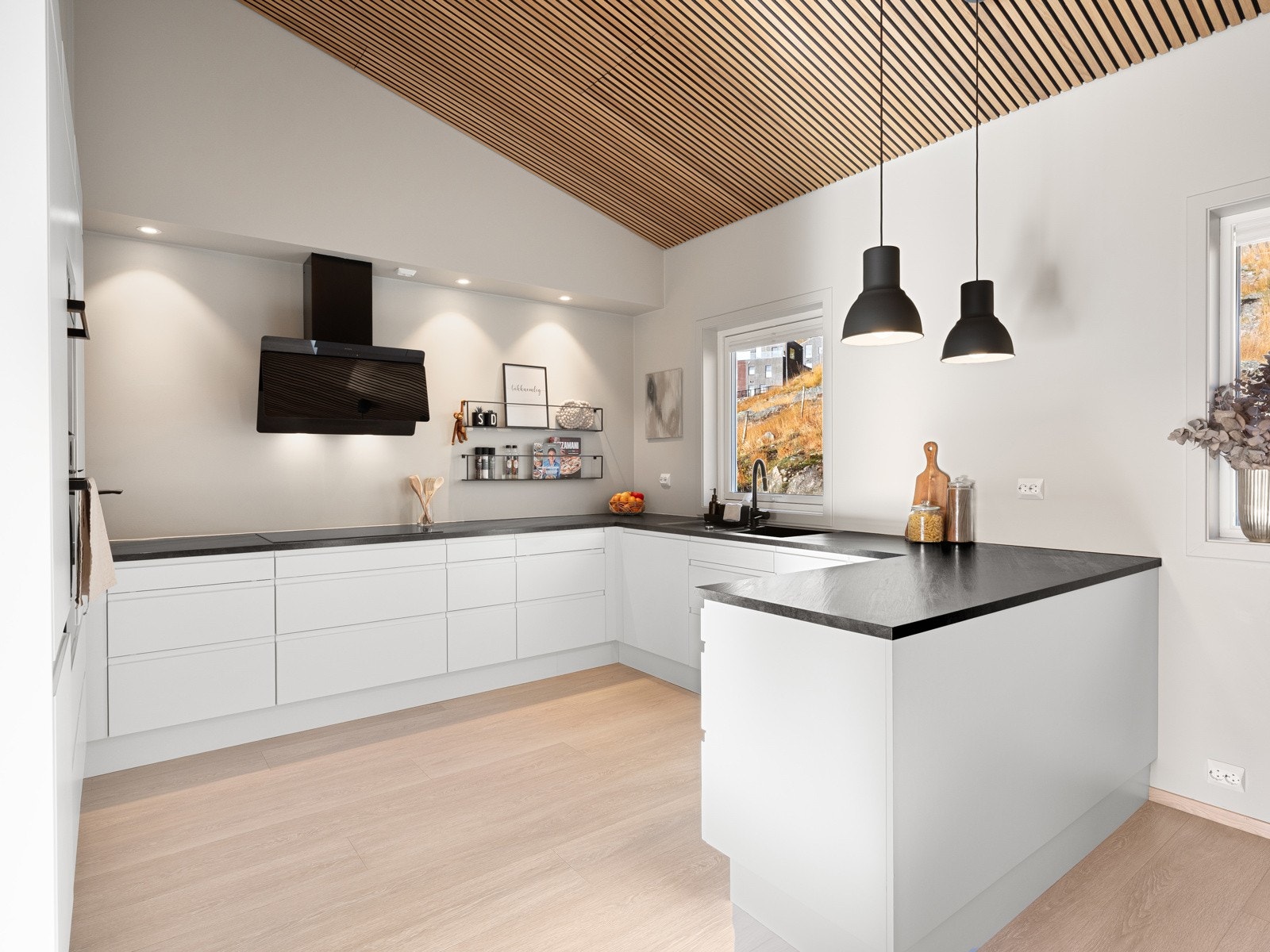 Velplasserte vinduer slipper naturen inn i både kjøkkenet og til spisebordet Galleribilde