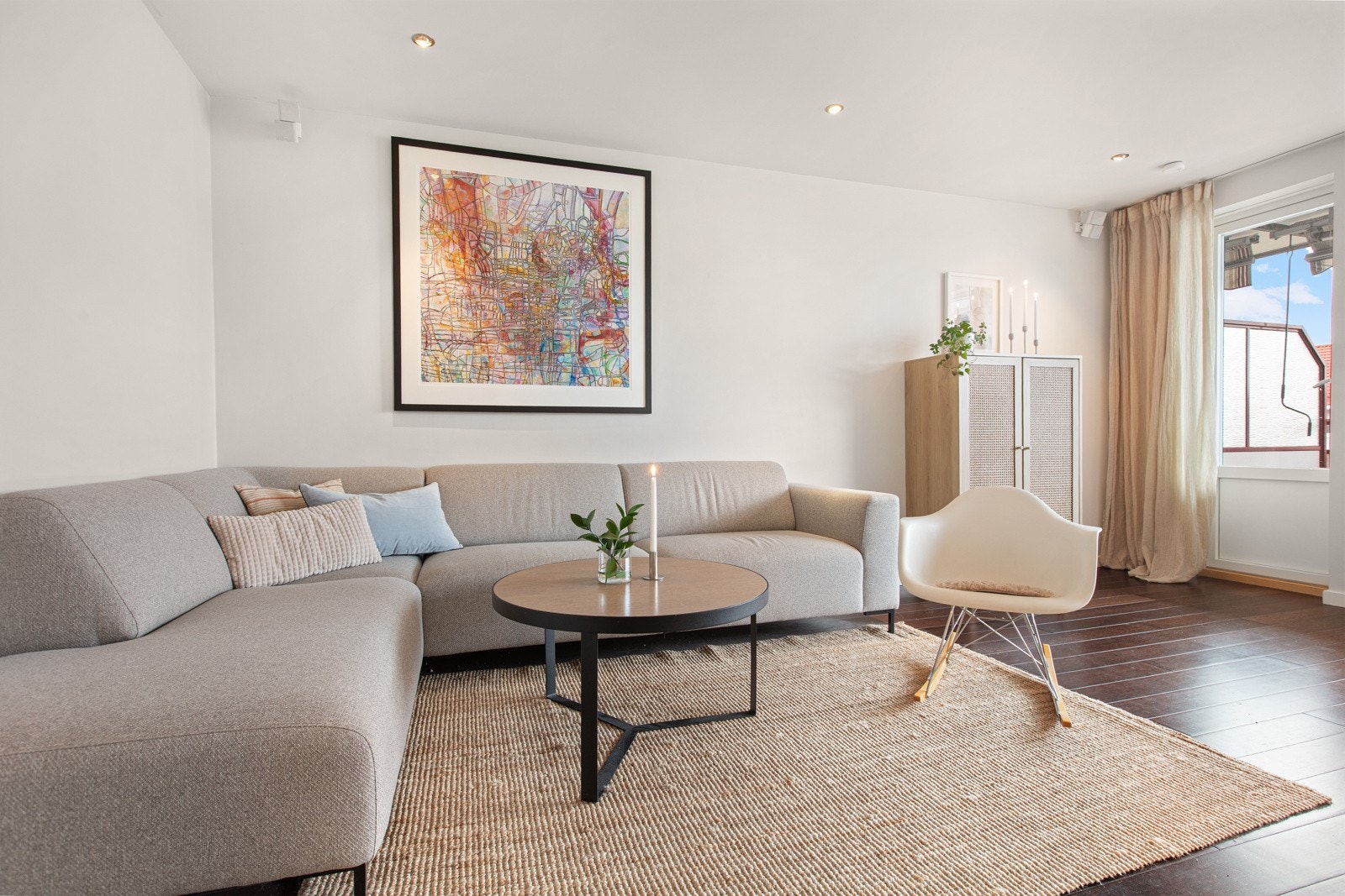Stuen har mørk parkett på gulvet som står i fin kontrast til de lyse overflatene, og det er utstrakt bruk av downlightsbelysning i taket. Galleribilde
