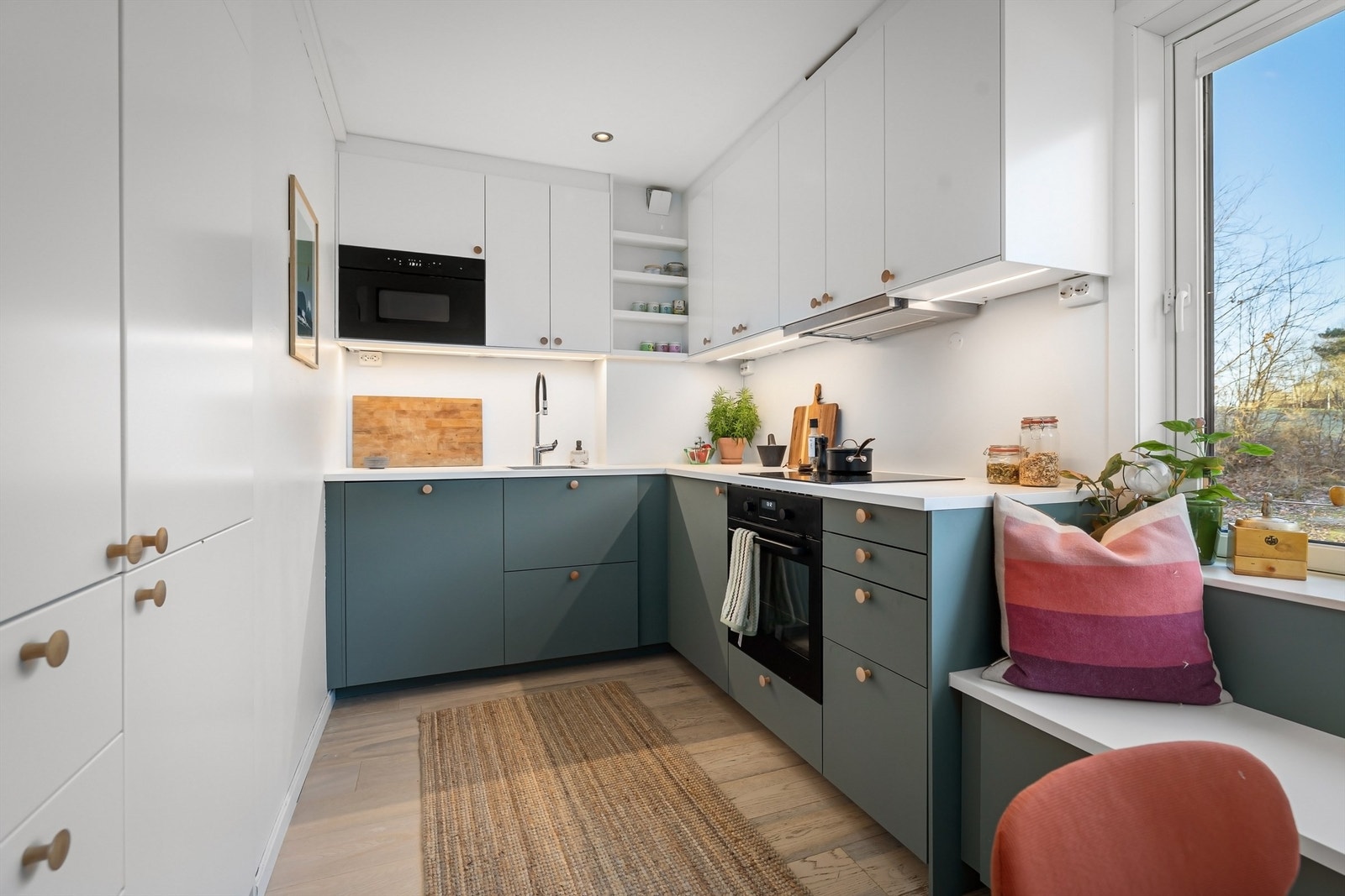 Kjøkkeninnredning fra Ikea med lyse, glatte fronter i to komplementære farger og benkeplate i hvit laminat Galleribilde