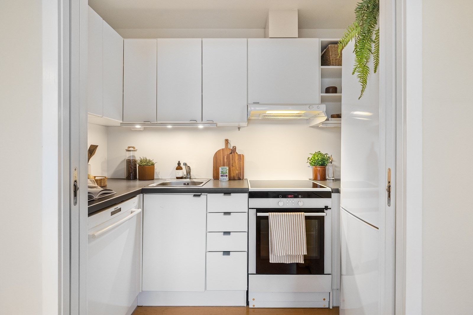 Innredning fra 2008 med glatte, hvite fronter og benkeplate i laminat. Galleribilde