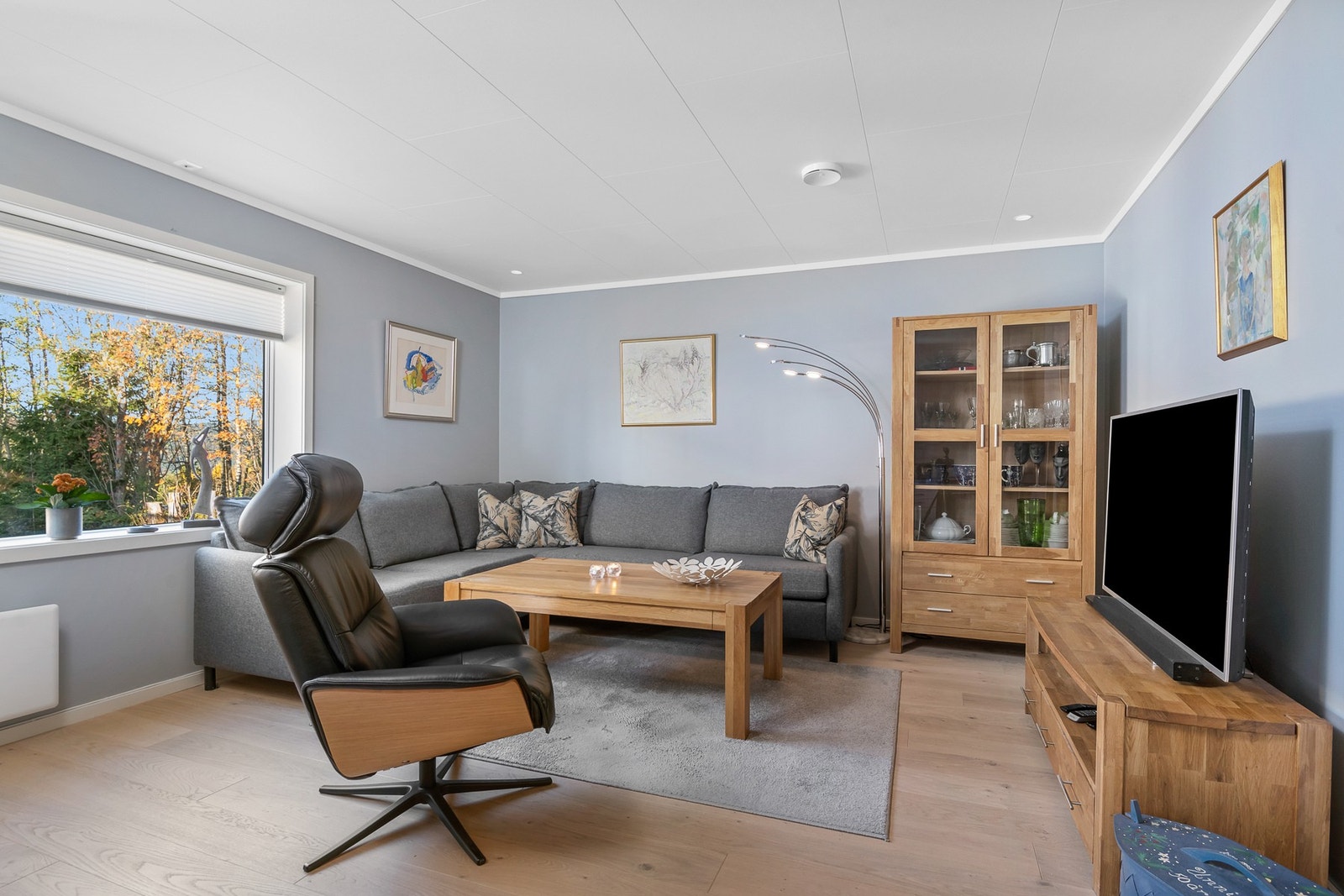 Stue med vindu, grå vegger, parkettgulv og hvitt tak. Lys og romslig atmosfære.
Foto: Tor Jensbakken. Galleribilde