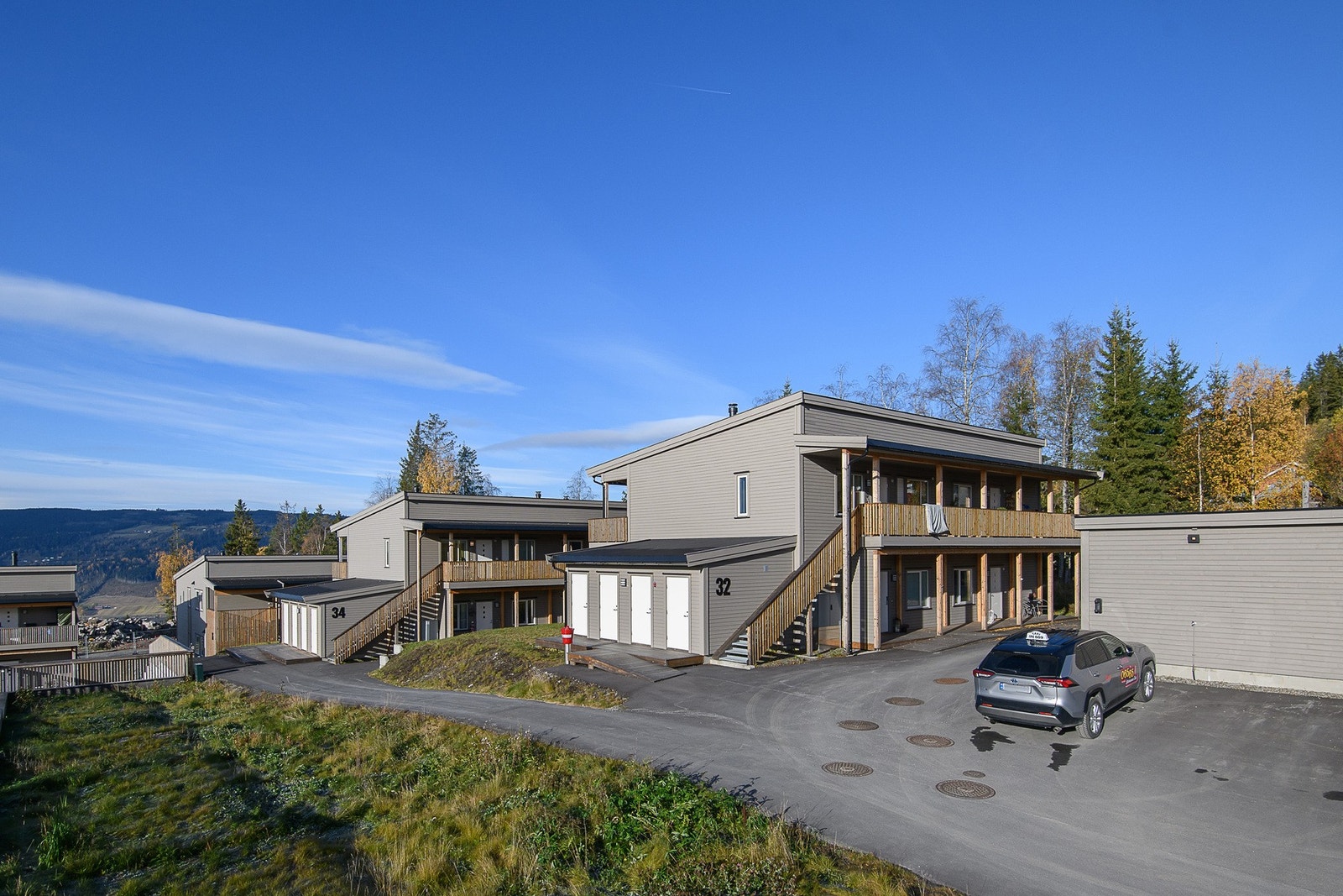 Det er felles parkeringsområde og gårdsplass med èn tilhørende plass i carport, samt utvendig bod på ca. 6 m² med innlagt strøm. Galleribilde