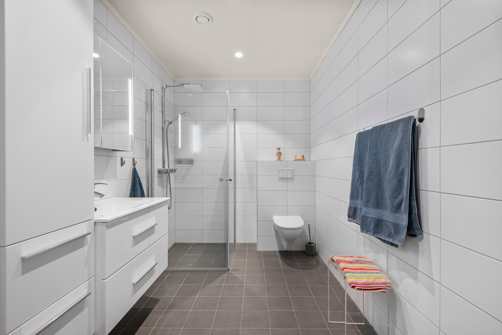 Badet har flislagt gulv med varmekabler og fliser på veggene. Galleribilde