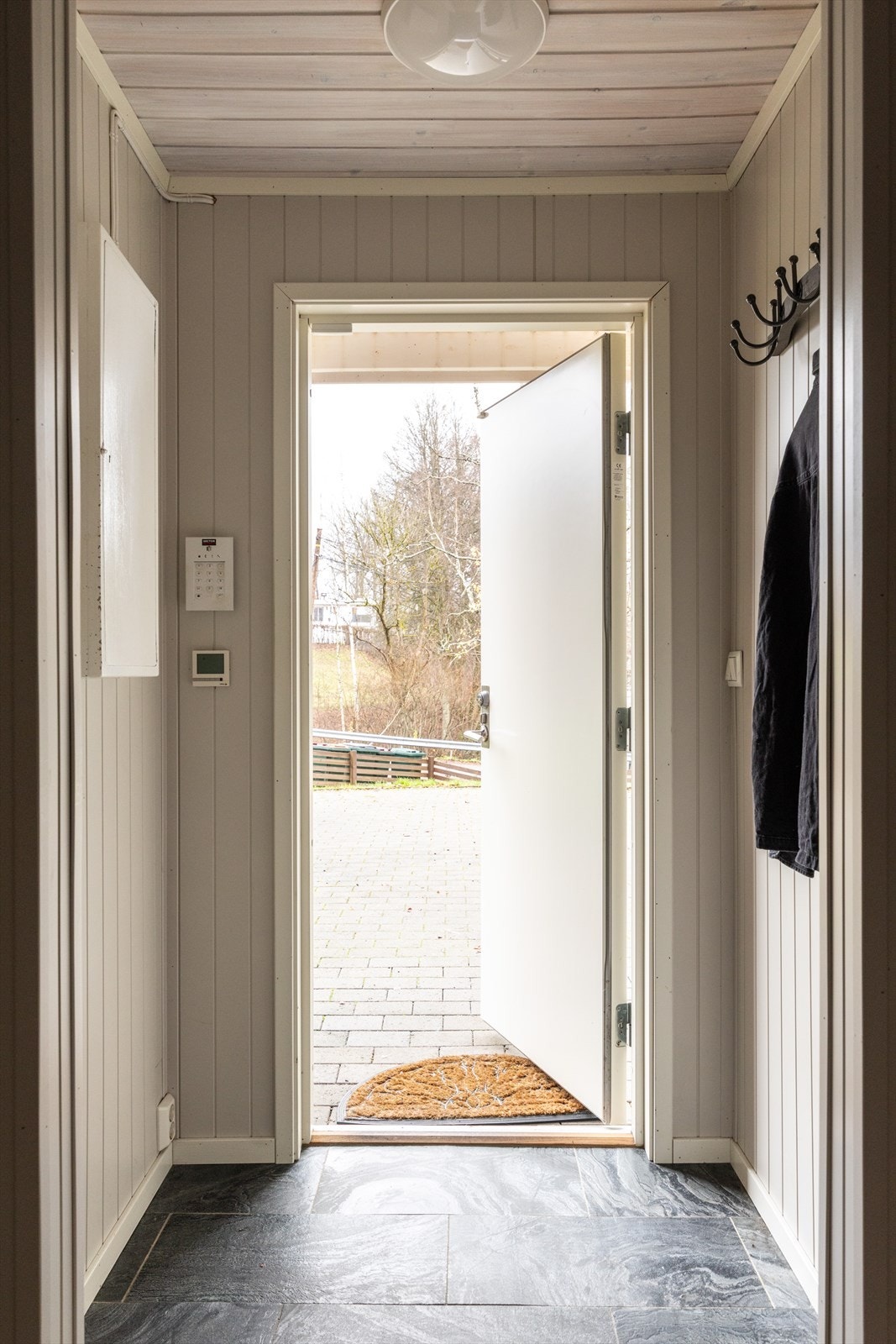 En koselig entré ønsker deg velkommen inn i en lys og tiltalende enebolig med fin standard, spennende planløsning og sosialt, familievennlig areal. Rommet har fin oppbevaringsplass for sko og yttertøy, og det er videre inngang til hallen. Galleribilde