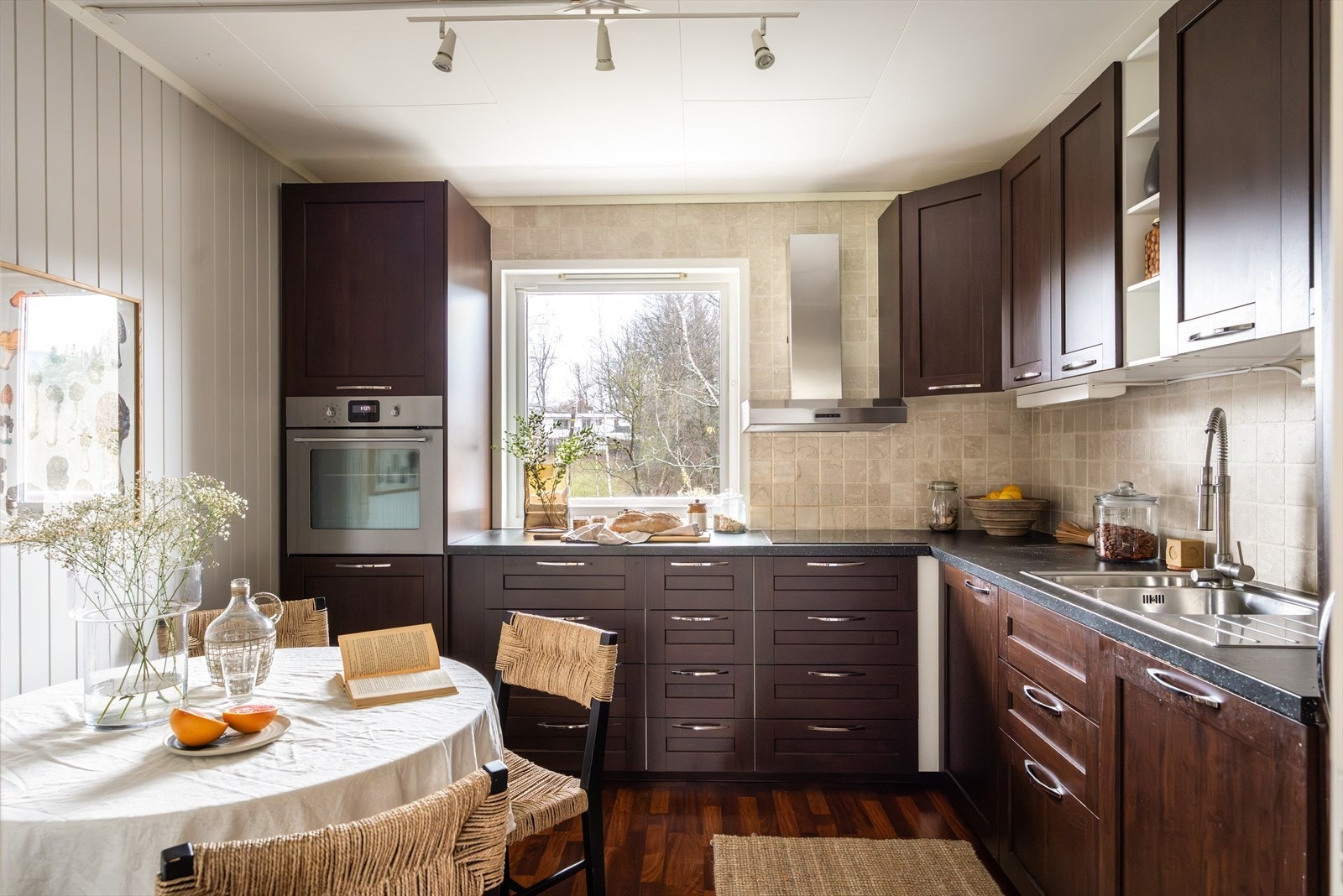 Kjøkkenet ligger i eget rom i hovedetasjen med døråpning mot boligens dagligstue og spisestue. Det er stort vindu i rommet som sikrer godt med dagslys i tillegg til en smakfull utførelse med mørkt laminatgulv, lysmalte vegger og plater i himlingen. Galleribilde