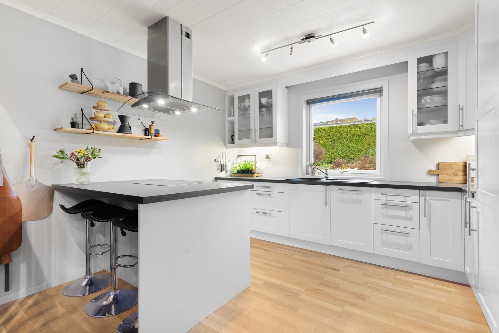 Pent kjøkken med barløsning som ligger i åpen løsning inn mot stuen. Galleribilde