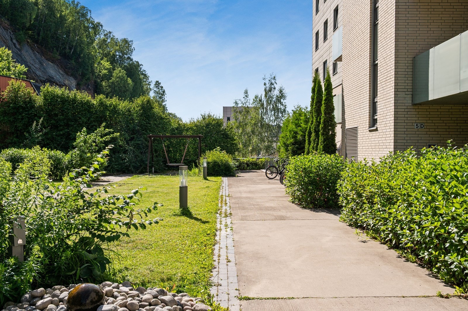 Felles tomten er pent opparbeidet med sitteplasser, velpleide plener og vakre beplantninger som skaper en trivelig og rolig atmosfære. Galleribilde
