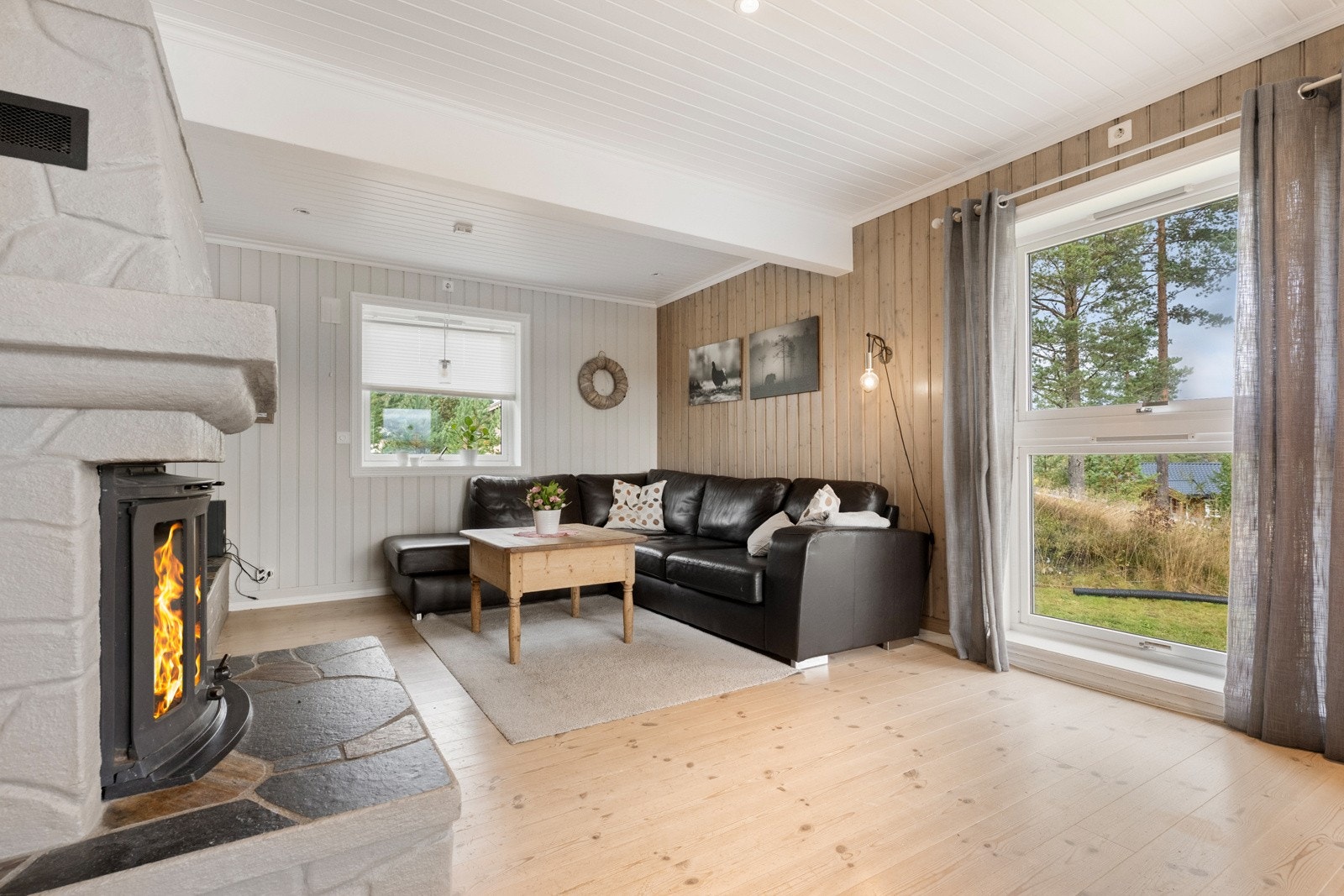 Peisen i rommet skaper en lun og trivelig atmosfære Galleribilde