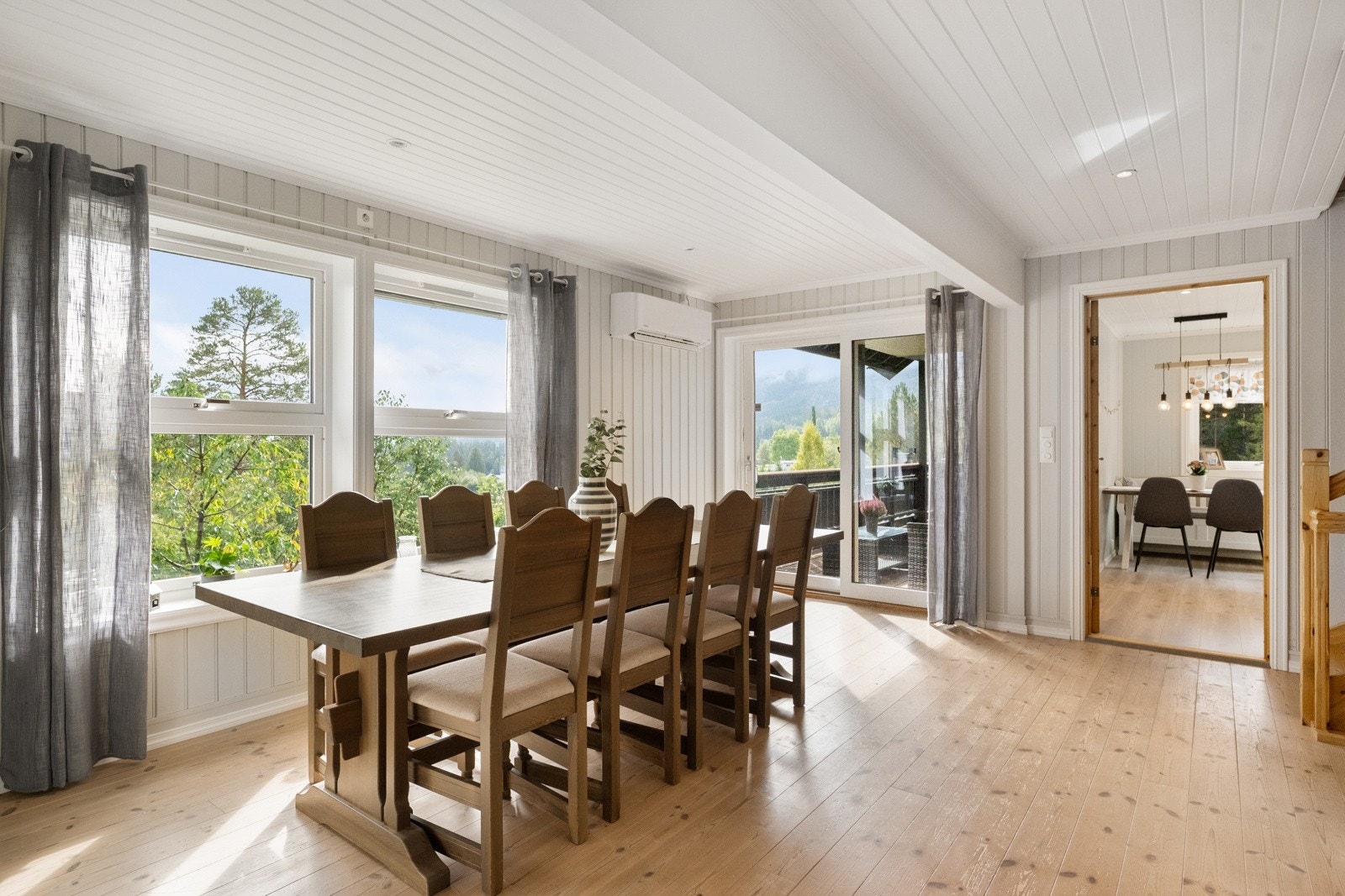 Spisestuen ligger i åpen og naturlig forlengelse av kjøkkenet, her er det montert varmepumpe på vegg Galleribilde