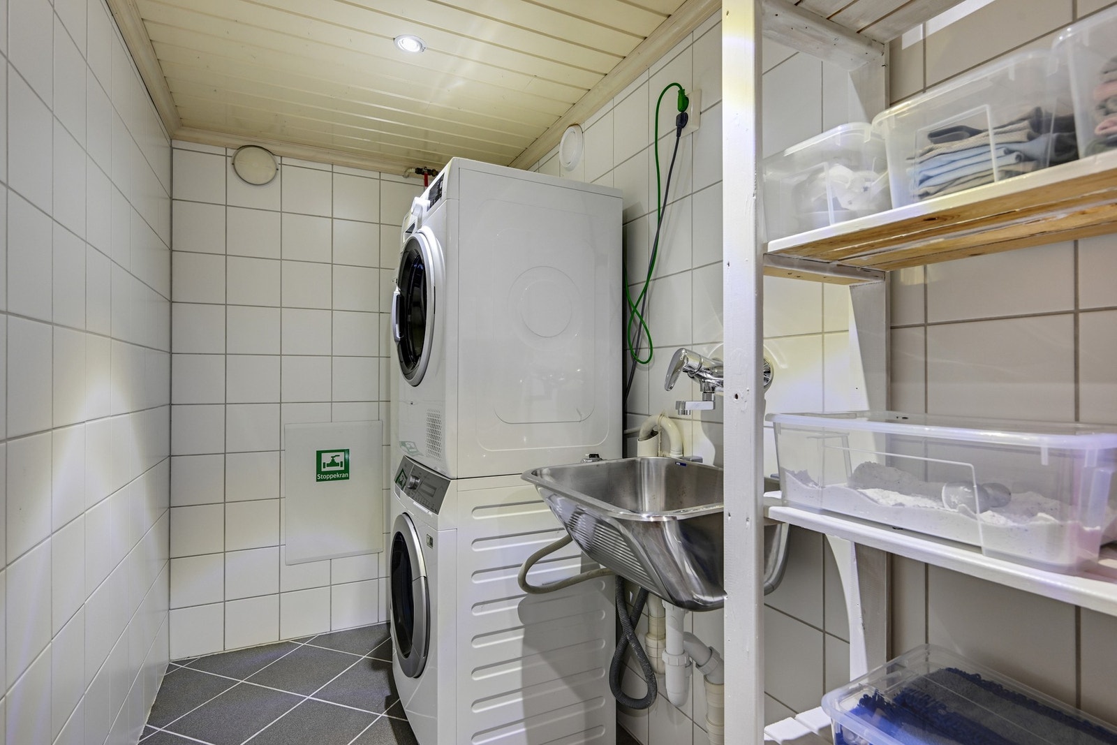 Flislagt vaskerom i kjelleren med god plass til både vaskemaskin og tørketrommel. Det er utslagsvask og plass til et hyllesystem for en praktisk hverdag. Galleribilde