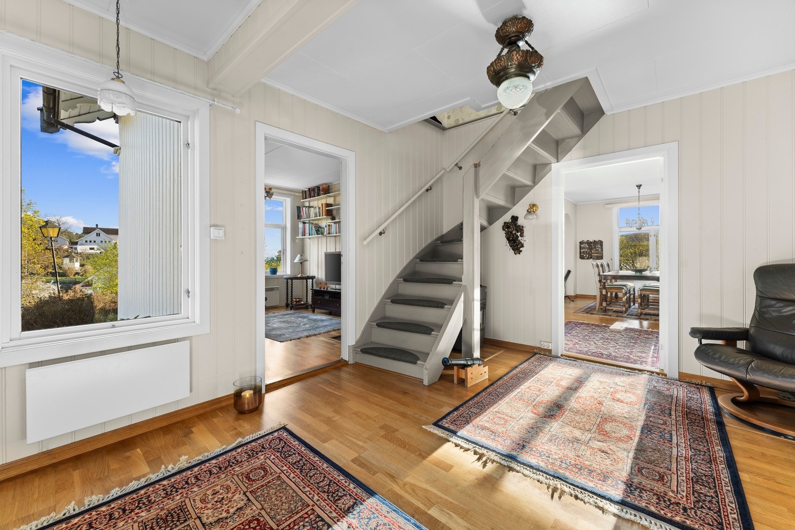 Stor representativ hall med trapp opp og inngang til stue, TV-stue og bad Galleribilde