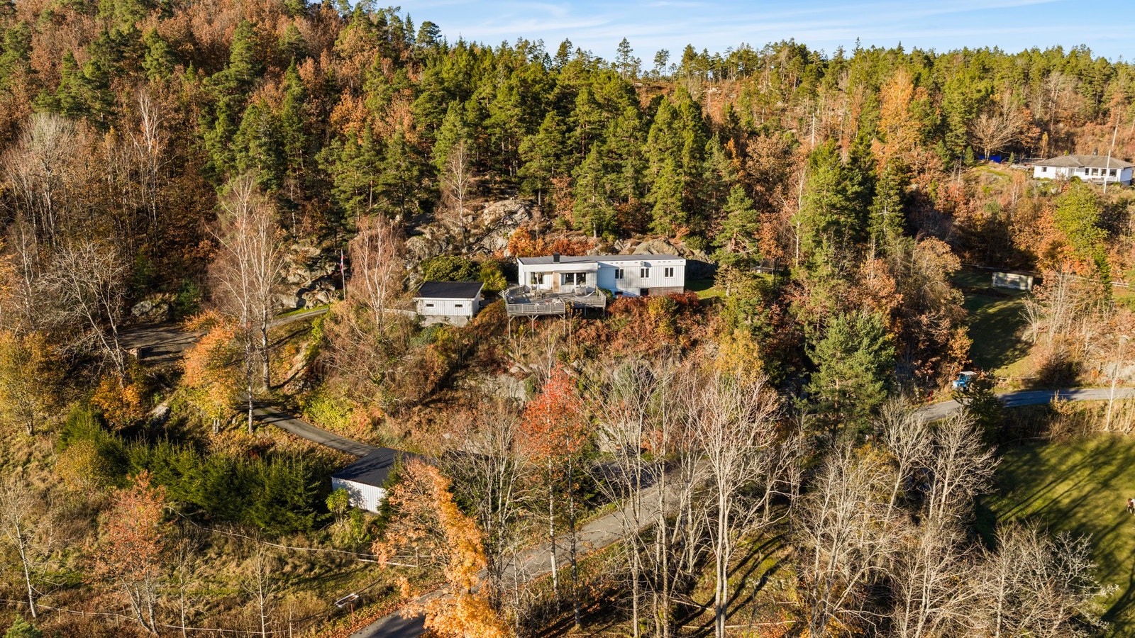Garasje nede ved veien og plass til flere biler på egen tomt både ved garasjen og nærmere boligen. Galleribilde