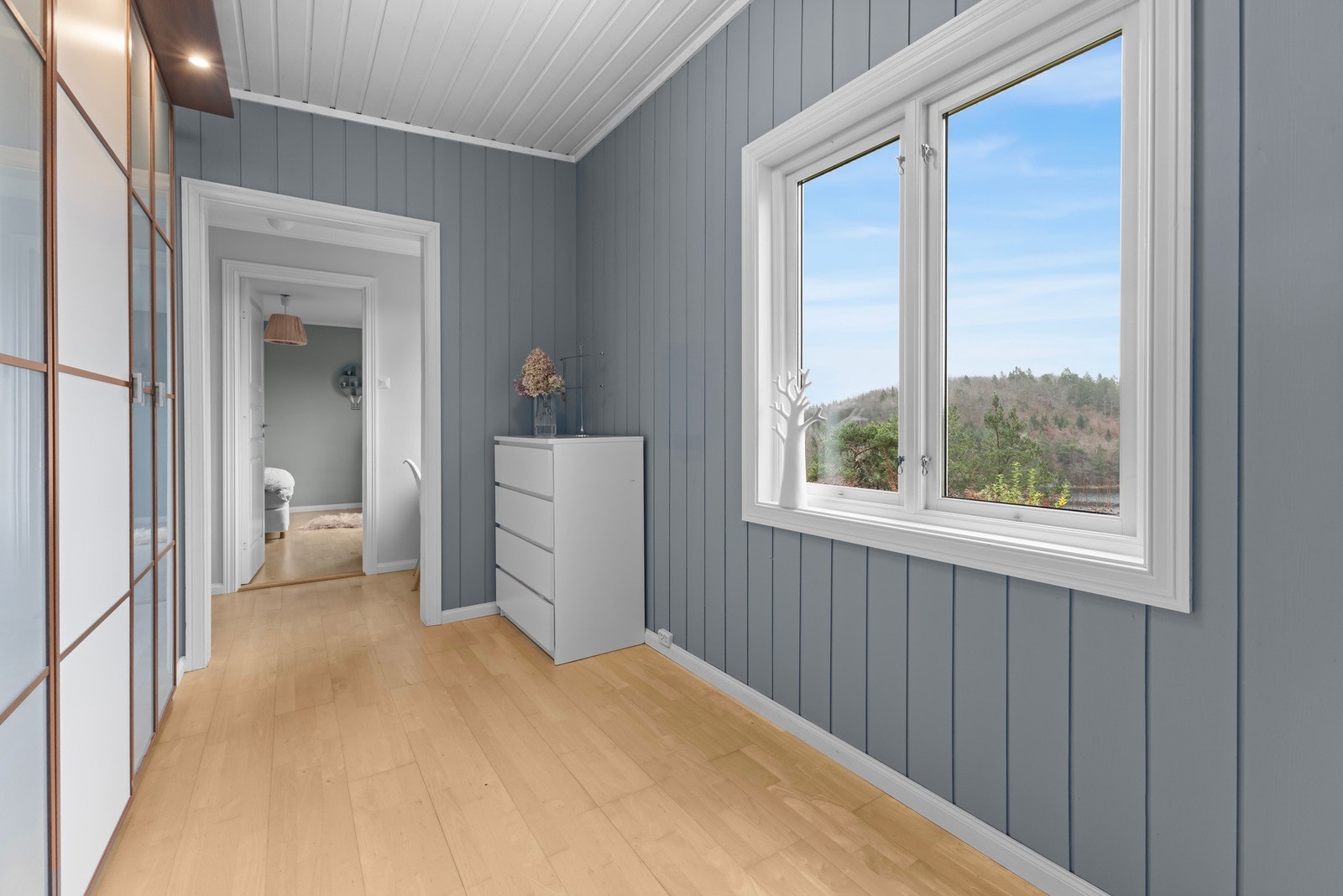 Praktisk gang med garderobe og plassbygde skap som binder oppholdsrom og soverom sammen. Galleribilde